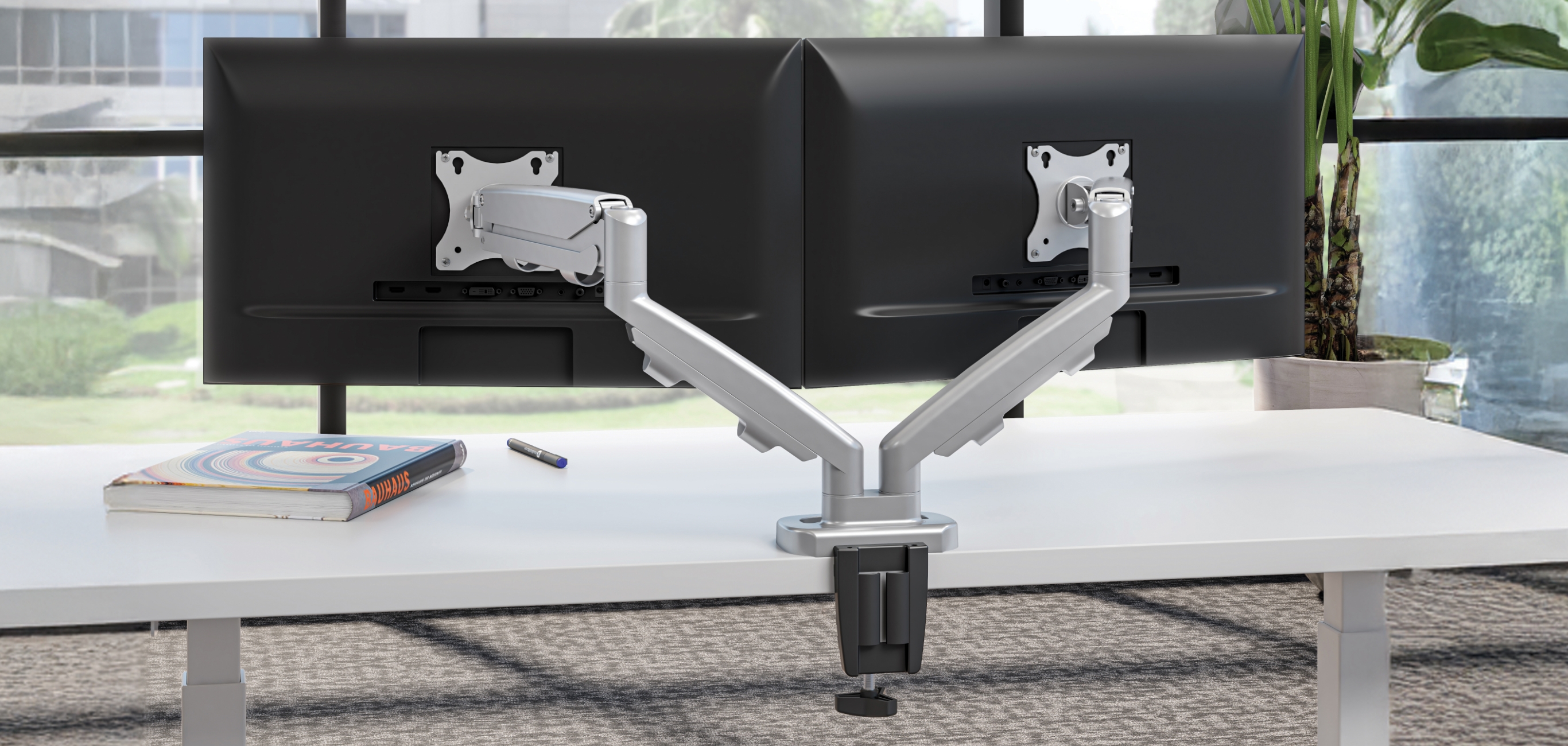 Image of a dual monitor arm attached to a desk